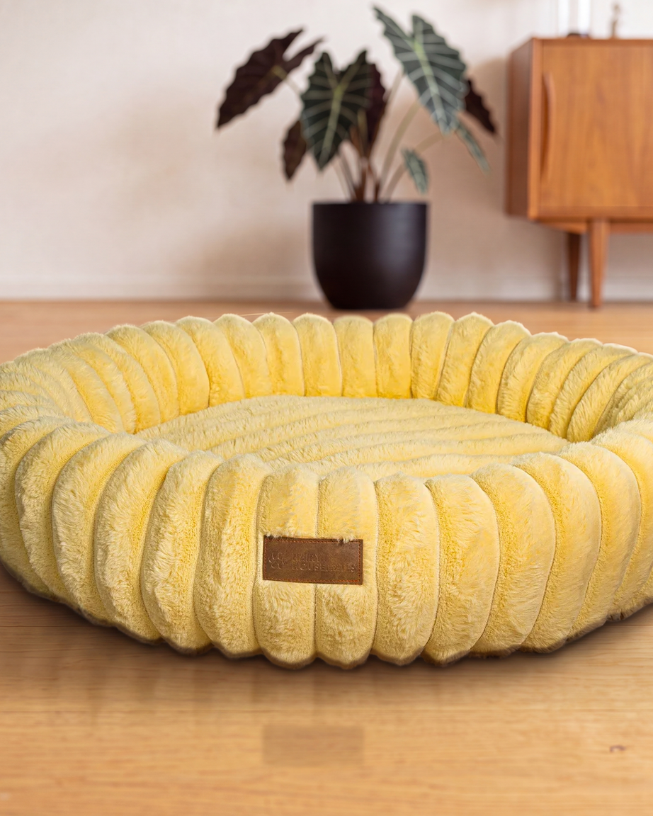 Hairy Housemates Corduroy dog bed in Butter, on the wooden floor