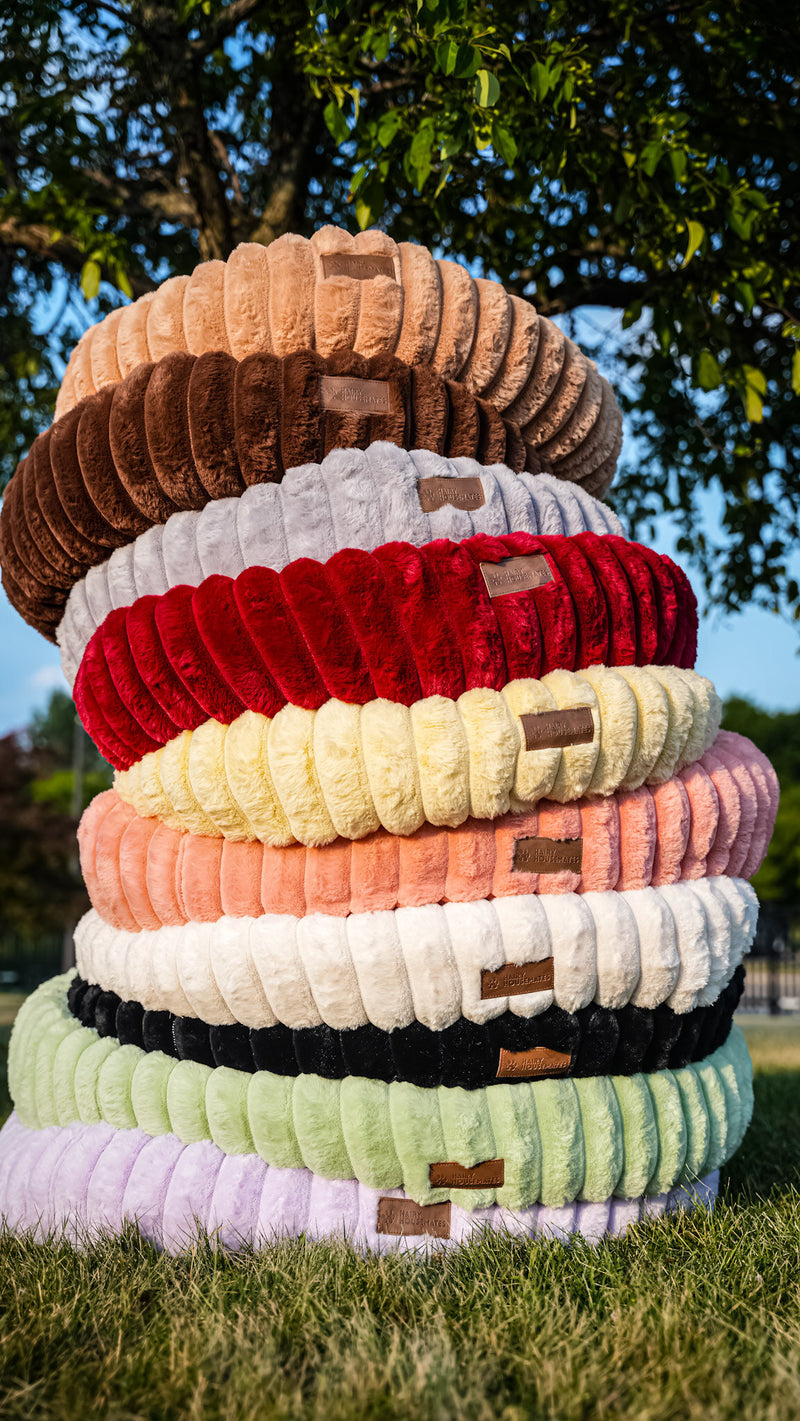 The full range of ten Hairy Housemates corduroy bed colourways stacked outdoors